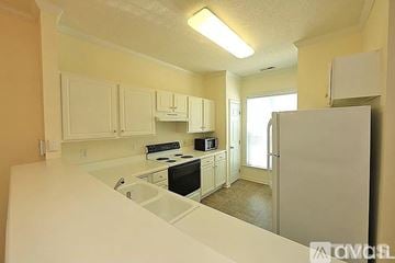 Raleigh apartment for rent - A kitchen with white cabinets and appliances.
