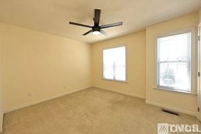 Raleigh apartment for rent - A room with a ceiling fan and two windows.