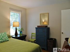 Charleston house for rent - A bedroom with a bed, a dresser, a chair, a table with a lamp and a mirror.