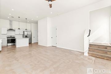San Antonio house for rent - A spacious kitchen with white cabinets and a wooden staircase.