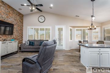 Surprise house for rent - A living room with a grey chair in the foreground and a brick wall on the left side.