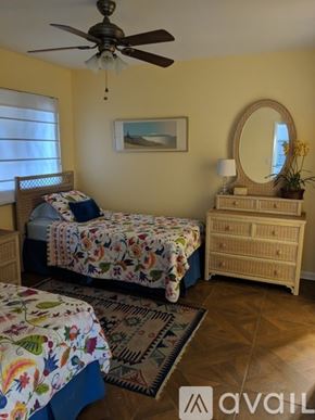 Sarasota condo for rent - A bedroom with a bed, dresser, and mirror.