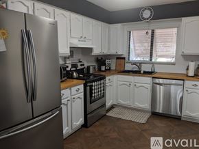 Sarasota condo for rent - A kitchen with white cabinets and a stainless steel refrigerator.