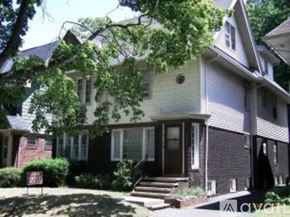 Cleveland Heights apartment for rent - A two-story house with a front porch and a tree in front.