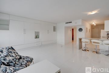 Miami Beach apartment for rent - A living room with a white couch and a patterned chair.