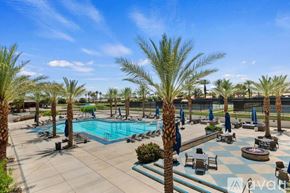La Quinta house for rent - A pool surrounded by palm trees and lounge chairs.