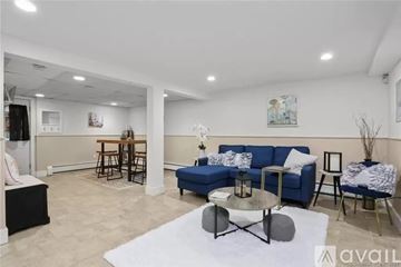 Trumbull apartment for rent - A living room with a blue sofa and a white rug.