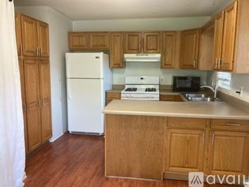 Charleston house for rent - A kitchen with wooden cabinets and a white refrigerator.