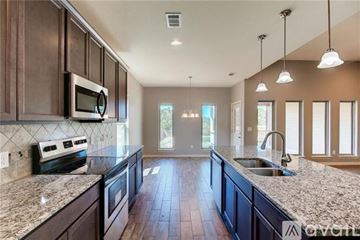 Leander apartment for rent - A kitchen with dark wood cabinets and granite countertops.