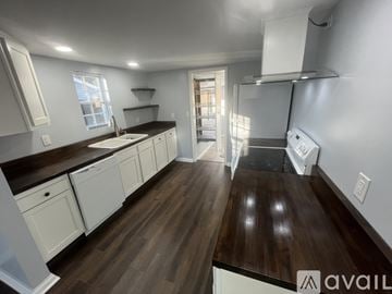 Knoxville house for rent - A kitchen with white cabinets and a wooden floor.