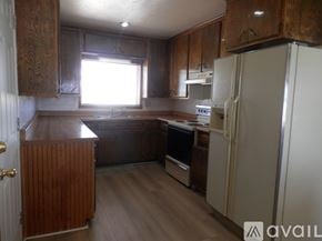 Landers apartment for rent - A kitchen with wooden cabinets and a white refrigerator.