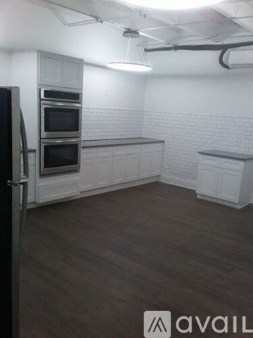 Natchitoches apartment for rent - A kitchen with a black refrigerator and white cabinets.