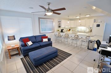 Panama City apartment for rent - A living room with a blue couch and a kitchen in the background.