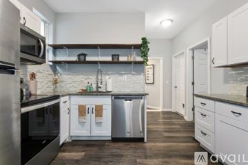 Kansas City apartment for rent - A kitchen with white cabinets and a marble backsplash.