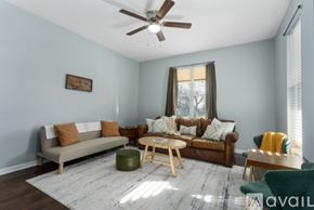 Kansas City apartment for rent - A living room with a brown couch, a green armchair, and a wooden coffee table.