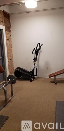 Natchitoches apartment for rent - A room with a vacuum cleaner and a wall-mounted exercise bike.