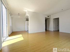 Los Angeles apartment for rent - A room with wooden floors and a large window.