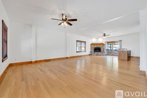 Reno house for rent - A spacious room with wooden floors and a fireplace.