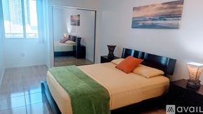 Miami condo for rent - A bedroom with a large bed and a painting on the wall.