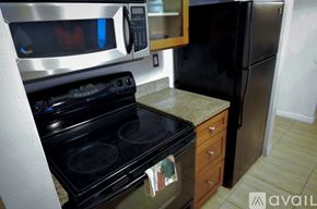 Miami condo for rent - A kitchen with a black oven and microwave.