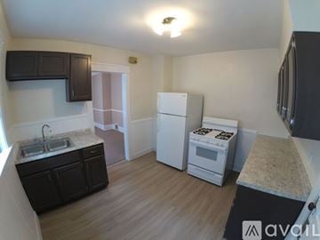 Erie house for rent - A kitchen with a sink, stove, and refrigerator.