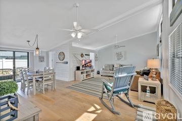 New Smyrna Beach condo for rent - A living room with a rocking chair and a dining table.