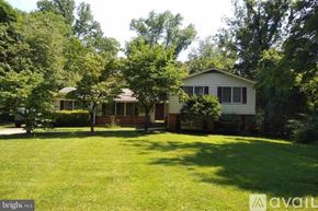 Fairfax house for rent - A house with a lawn and trees in front of it.