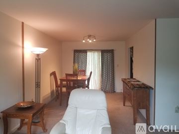Clinton house for rent - A living room with a white chair and a wooden table.