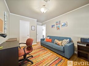 Tulsa house for rent - A living room with a blue couch and a red chair.