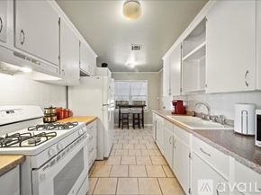 Tulsa house for rent - A kitchen with white cabinets and a tiled floor.
