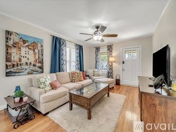 Tulsa house for rent - A living room with a couch, a coffee table, and a painting on the wall.
