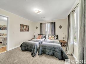 Tulsa house for rent - A bedroom with two beds and a carpeted floor.