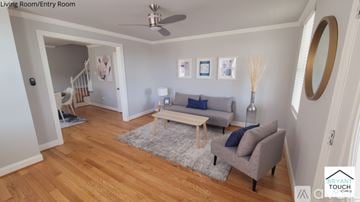 Baltimore house for rent - A living room with a grey couch and a grey rug.