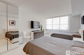 Miami Beach condo for rent - A bedroom with a large bed and a flat screen TV mounted on the wall.