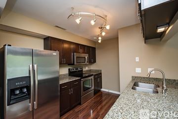 Iowa City apartment for rent - A kitchen with a refrigerator, microwave, oven, sink and cabinets.