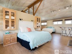 El Segundo townhouse for rent - A bedroom with a large bed and wooden furniture.