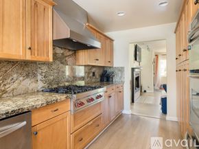 El Segundo townhouse for rent - A kitchen with wooden cabinets and a marble countertop.