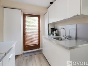 El Segundo townhouse for rent - A kitchen with white cabinets and a white fridge.