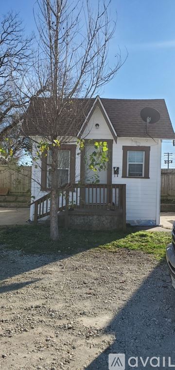 Marlin apartment for rent - A small white house with a brown roof and a tree in front.