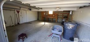 Cheney house for rent - A large garage with a trash can and a table in it.