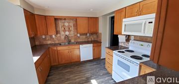 Cheney house for rent - A kitchen with wooden cabinets and a white stove top oven.