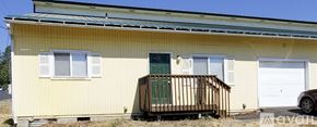 Cheney townhouse for rent - A yellow house with a green door and a white garage door.