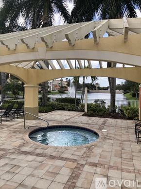 Palm Beach Gardens condo for rent - A pool area with a white pergola and a small pool.