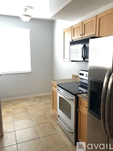 Palm Beach Gardens condo for rent - A kitchen with a black counter top and stainless steel appliances.
