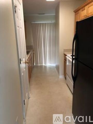 Cartersville apartment for rent - A kitchen with a black fridge and wooden cabinets.