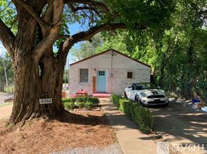 Nashville apartment for rent - A white car is parked in front of a small house with a blue door.