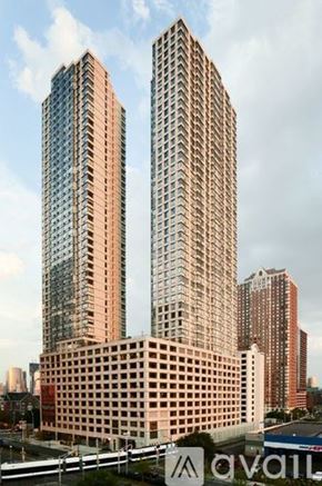 Jersey City apartment for rent - Two tall buildings are in the foreground with a third building in the background.