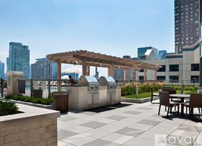 Jersey City apartment for rent - A patio with a table and chairs and a grill.