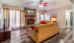 Broken Arrow house for rent - A living room with a couch, television, and fireplace.