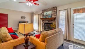 Broken Arrow house for rent - A living room with a couch, a lamp, and a fireplace.